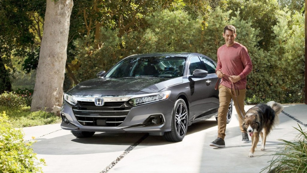 Man walking dog by 2022 Honda Accord, the U.S. News best midsize car for families to buy in 2022
