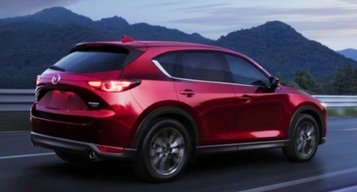 A red 2022 Mazda CX-5 small SUV drives down the highway.