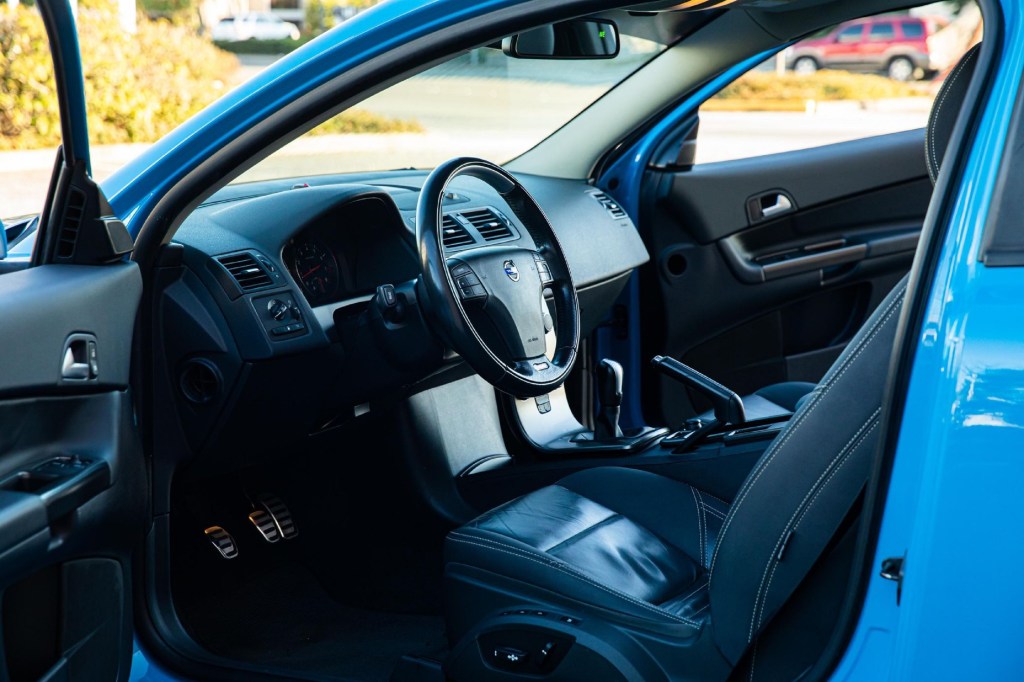 The black-leather front seats and black dashboard of a blue modified manual 2013 Volvo C30 R-Design with a Polestar tune