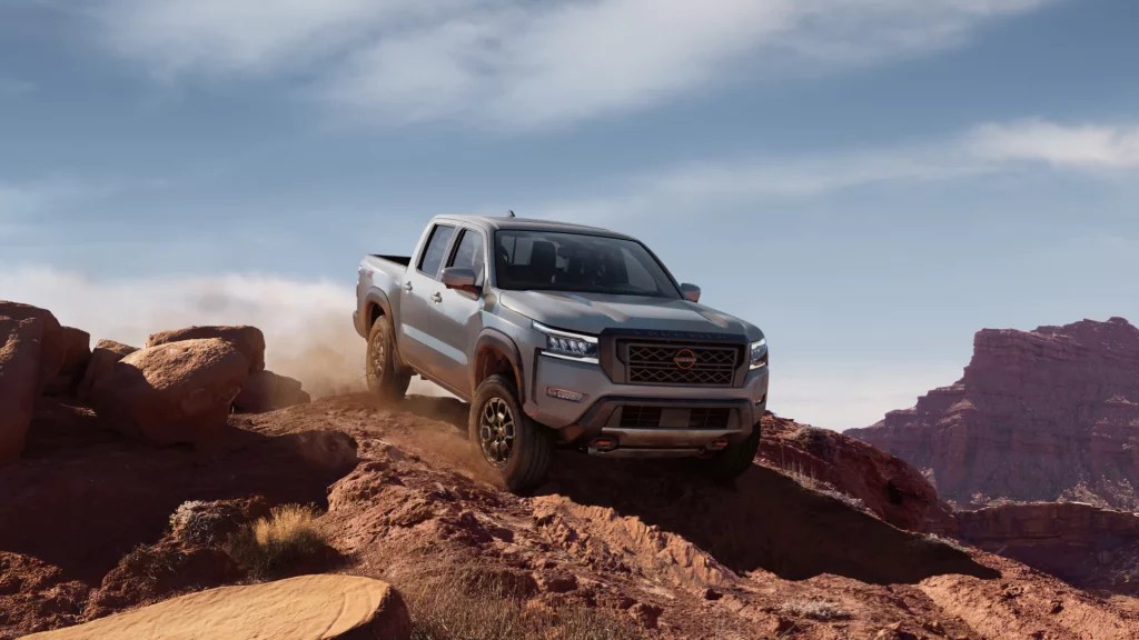 The 2022 Nissan Frontier crawls over rugged terrain.
