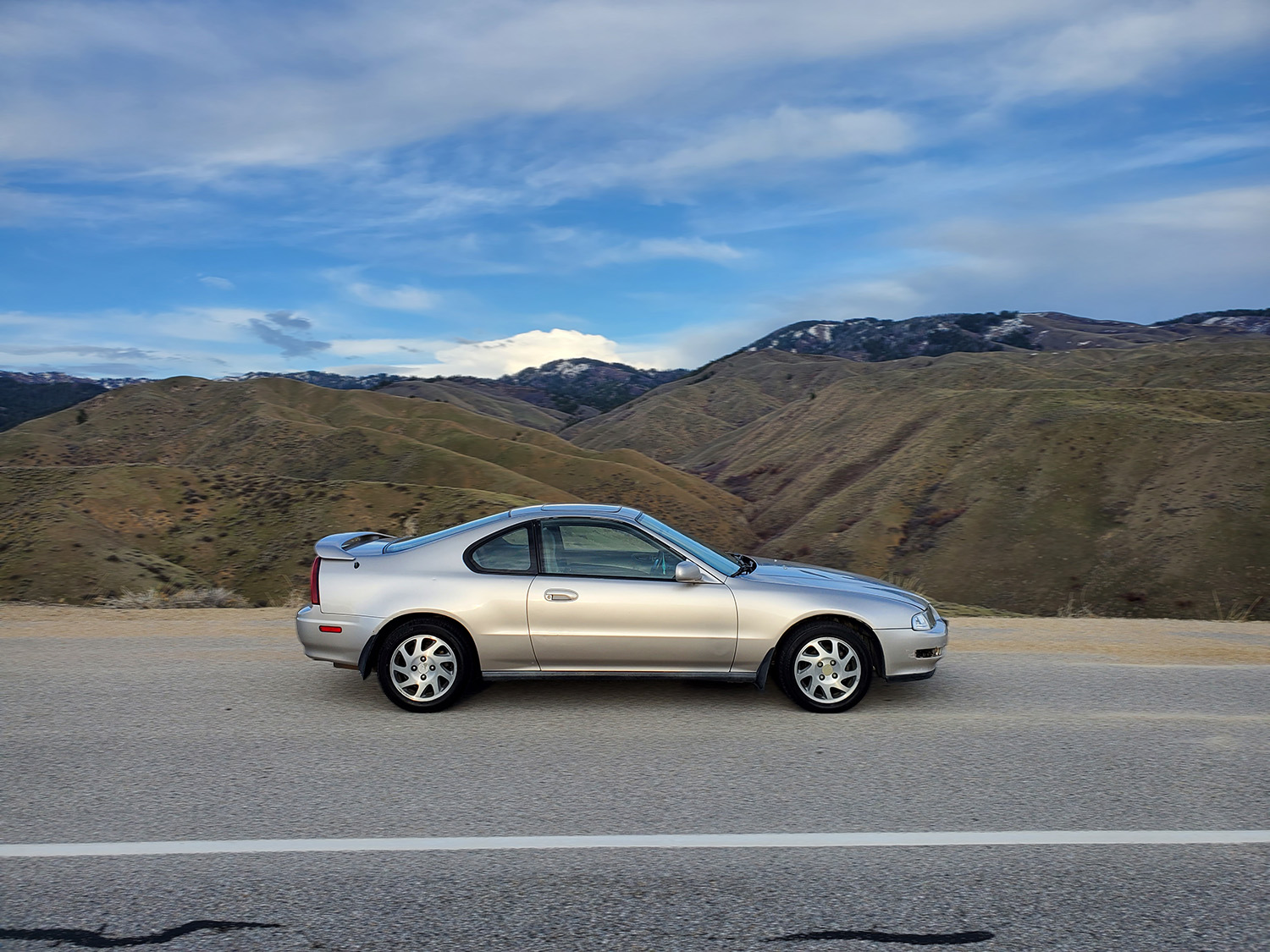 Silver 1996 Honda Prelude Si parked on mountain road with valley in background, passenger side