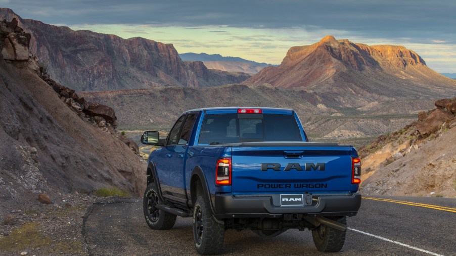 Blue Dodge Power Wagon parked on a road above a sandy mountain range.