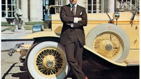 Robert Redford playing Jay Gatsby, leaning against a 1928 Roll-Royce car.
