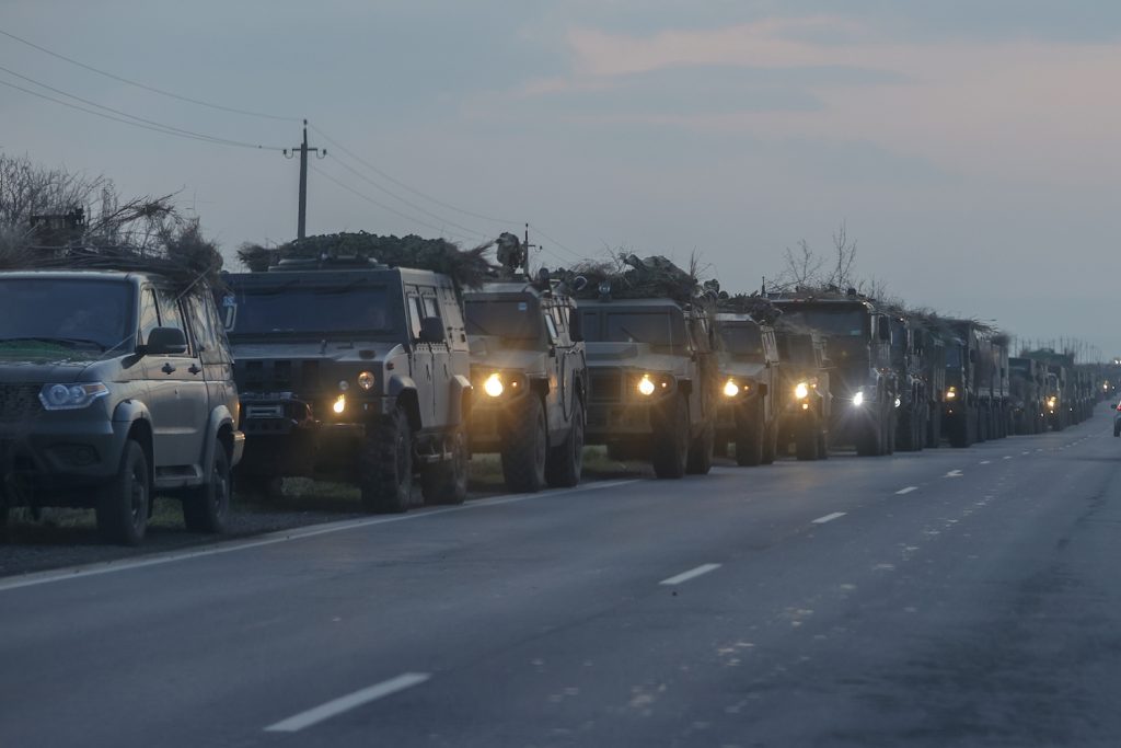 A convoy of Russian military vehicles parked on a Ukranian road at twilight.
