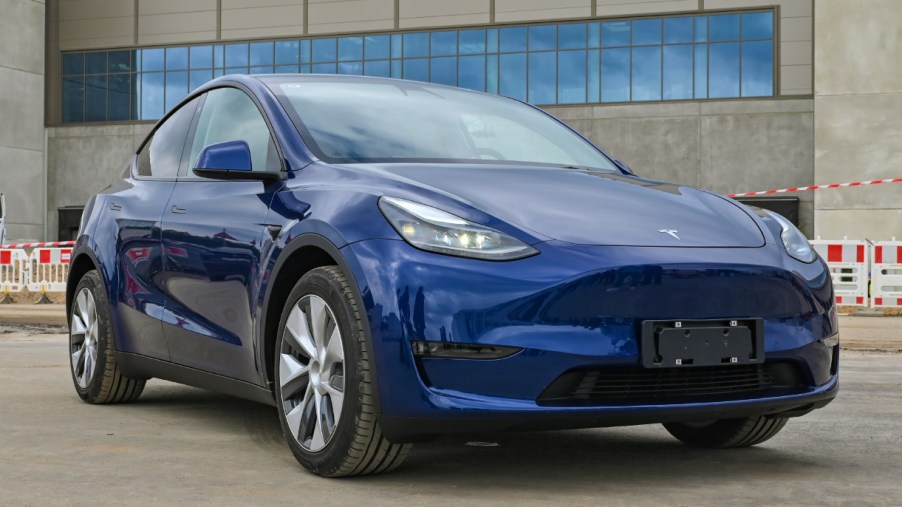 A blue Tesla Model Y is parked.