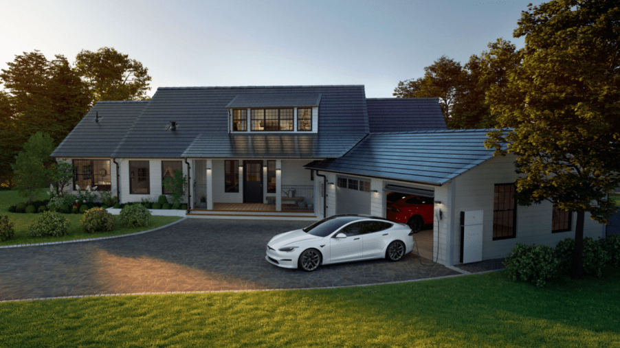 Tesla Model S plugged into a Tesla wall charger at home outside of a garage