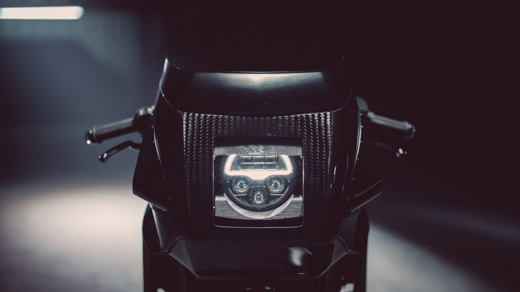 The partially-open headlight coverings on Workhorse Speed Shop's carbon-fiber Indian FTR 'Black Swan'