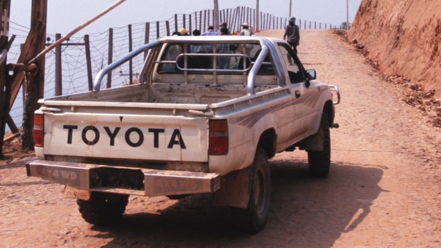 A white Toyota Pickup is driving off-road.