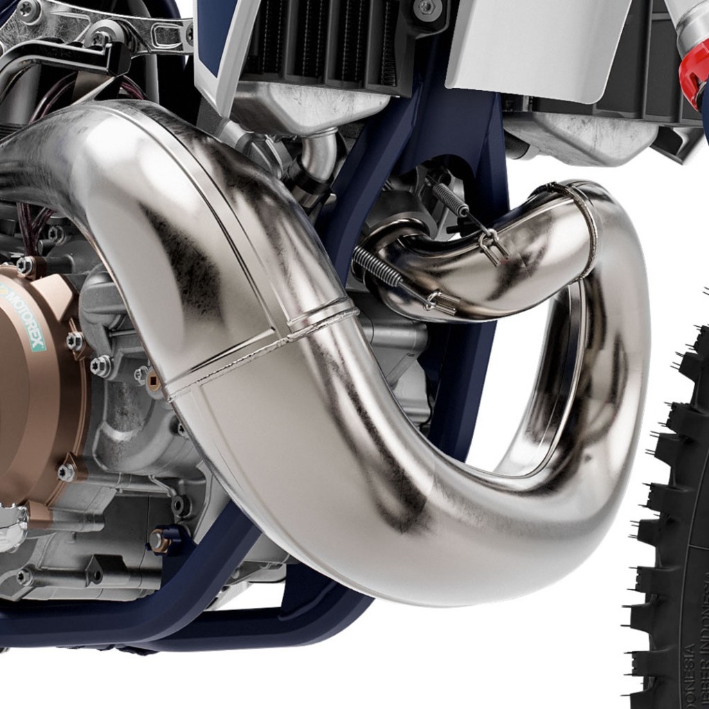 The exhaust header on a two-stroke white-and-blue 2022 Husqvarna TC 250 dirt bike