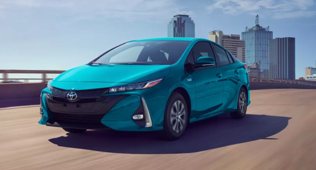 A blue 2022 Toyota Prius Prime is driving on the road. 