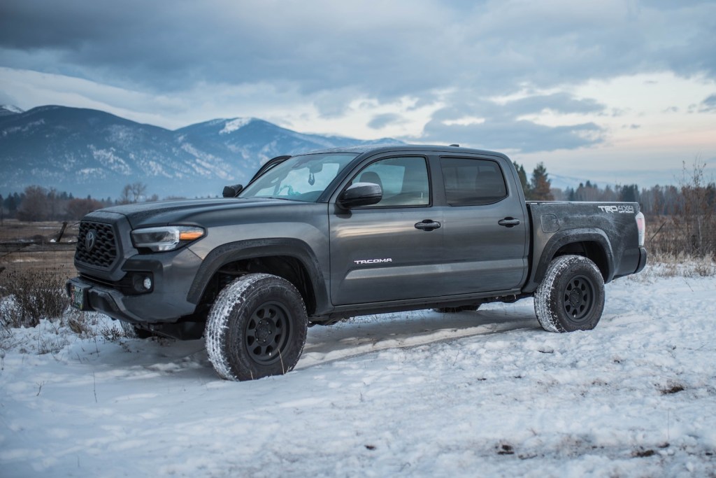 Gray Toyota Tacoma parked in a snowy field.