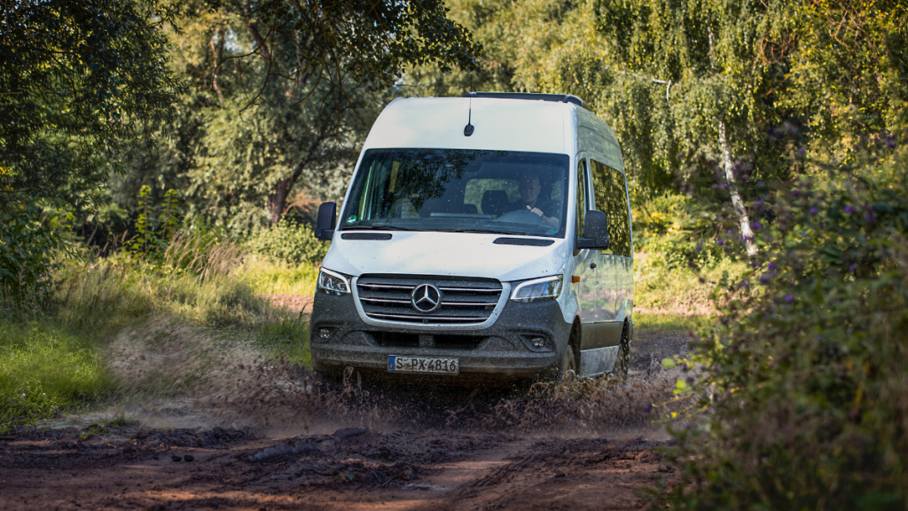White 2023 Mercedes-Benz Sprinter Passenger Van driving off-road, highlighting its release date and price