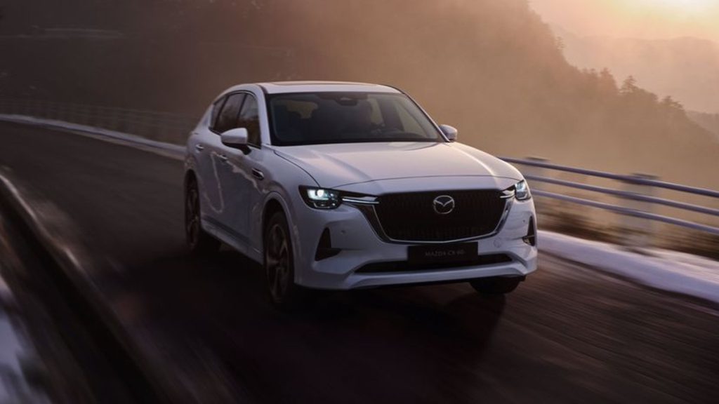 White Mazda CX-60 driving on a mountain road, highlighting release date and price of 2023 Mazda CX-70