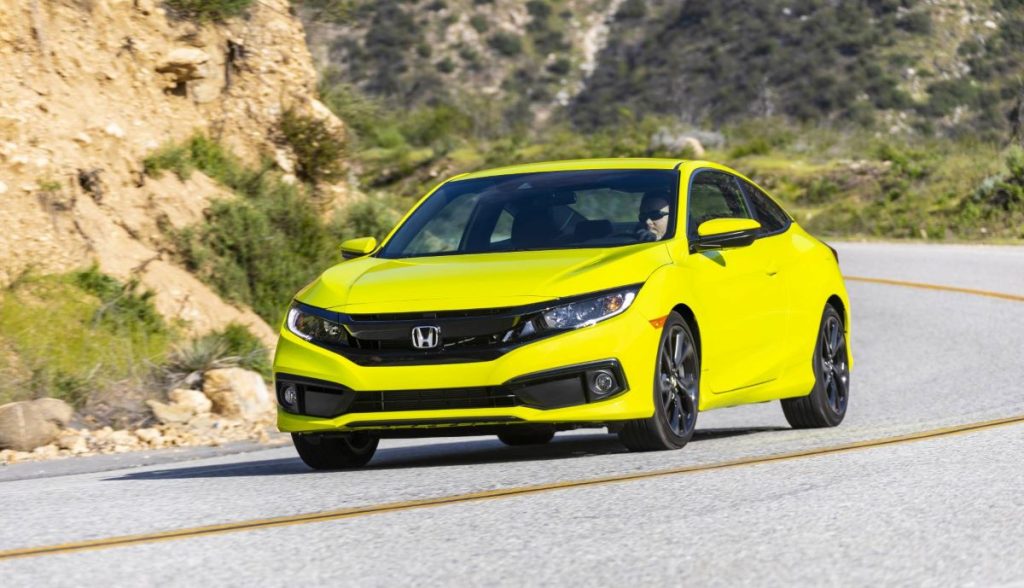 Yellow Honda Civic Coupe driving on a curvy road, the best car for commuting in 2022