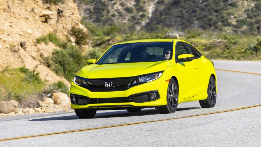 Yellow Honda Civic Coupe driving on a curvy road, the best car for commuting in 2022