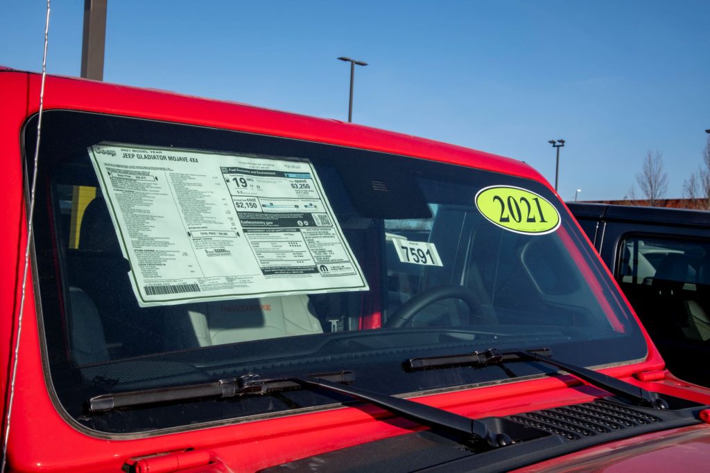 2021 Jeep Gladiator sticker price and MSRP on a car dealership lot in Lansing, Kansas