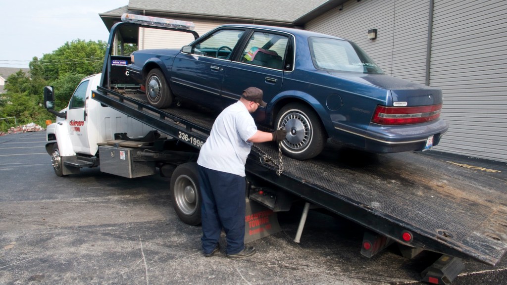 American Buick car loaded onto a tow truck.