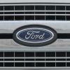 Closeup of a Ford logo nameplate on the front grille of an unidentified vehicle