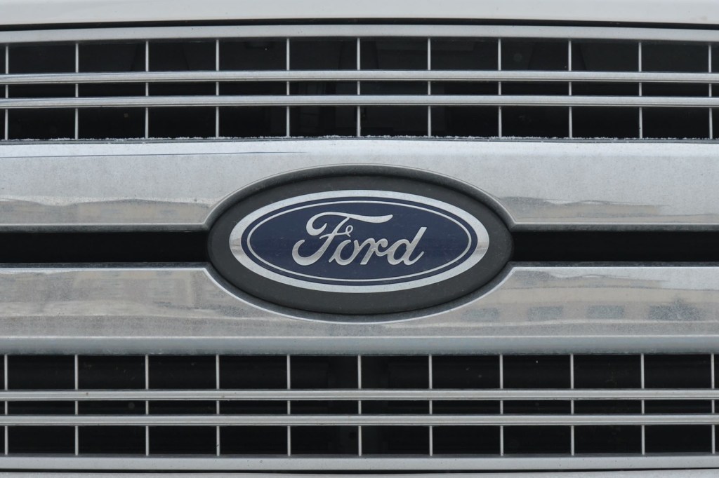 Closeup of a Ford logo nameplate on the front grille of an unidentified vehicle
