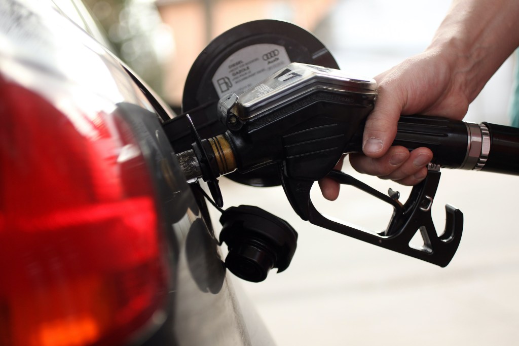A gas pump delivers fuel into a car. 
