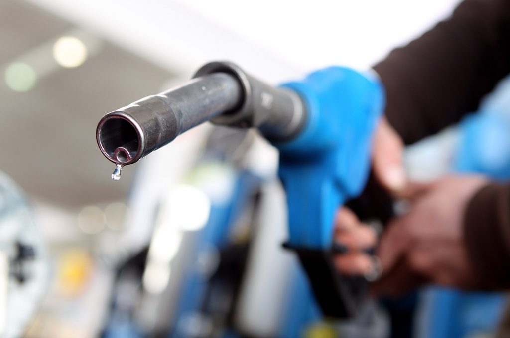 A gas pump nozzle close up, Should you turn off your car while pumping gas?