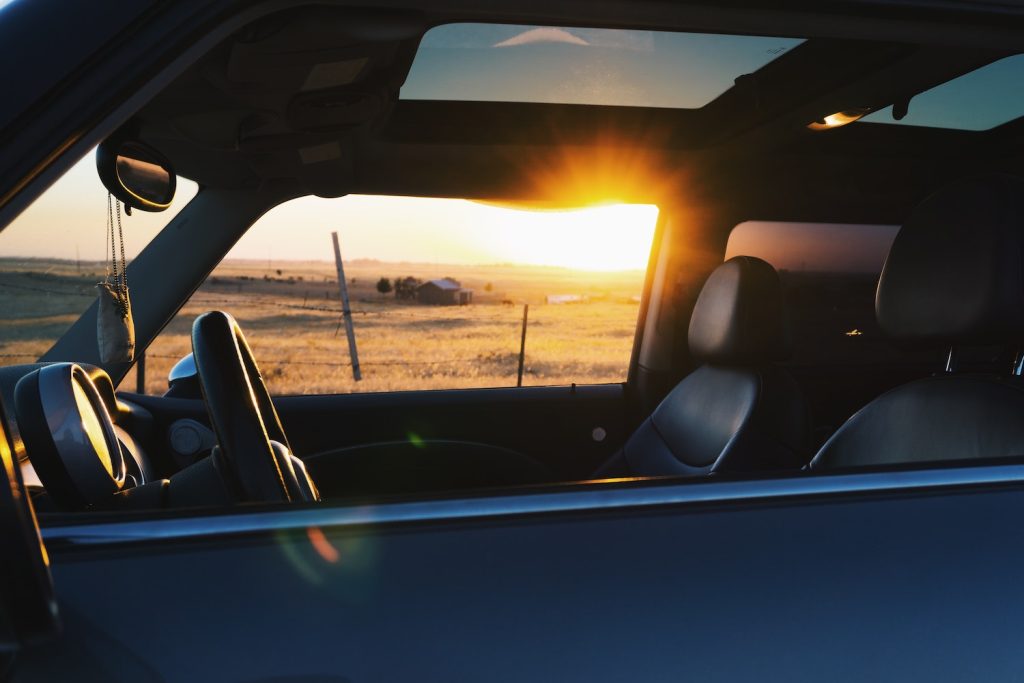 An interior view of a car and its sunroof at dusk