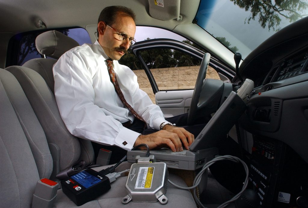 A man works on his laptop with a wireless connection in a car