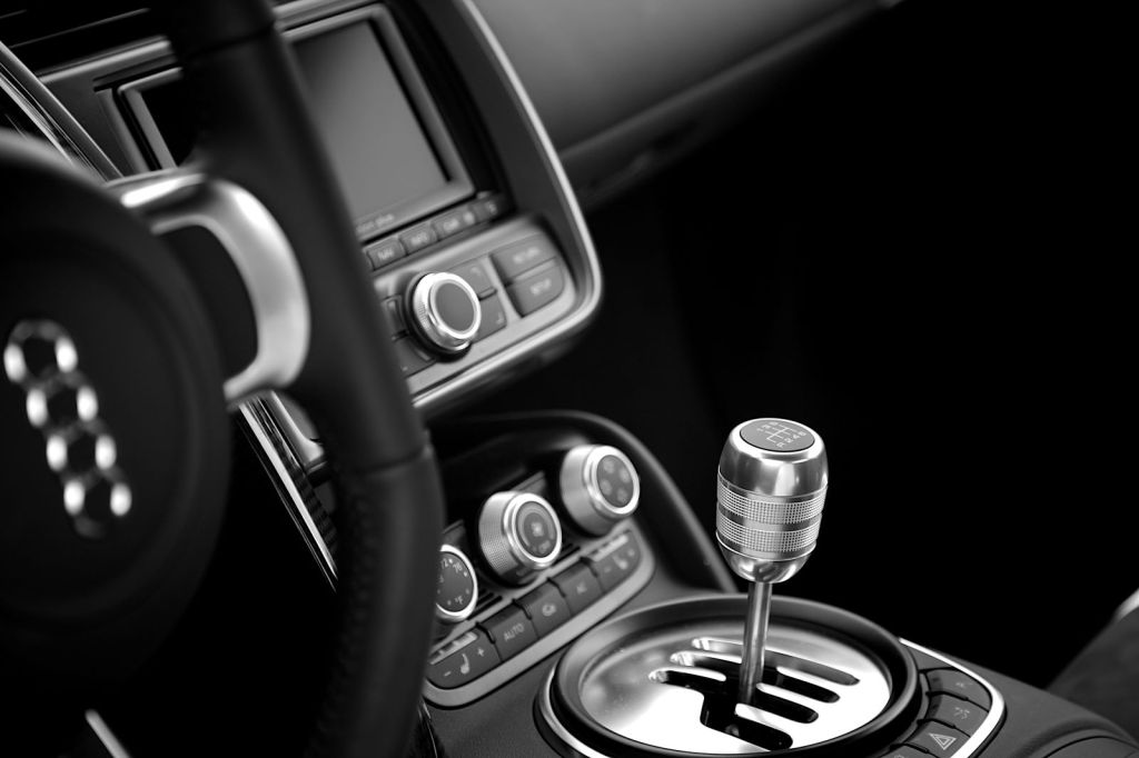 Black and white view of a car's interior, focusing on the manual transmission shifter