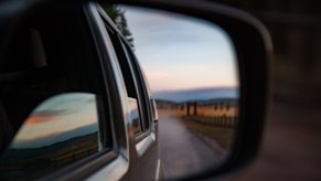 A reflection of car windows in the side mirror