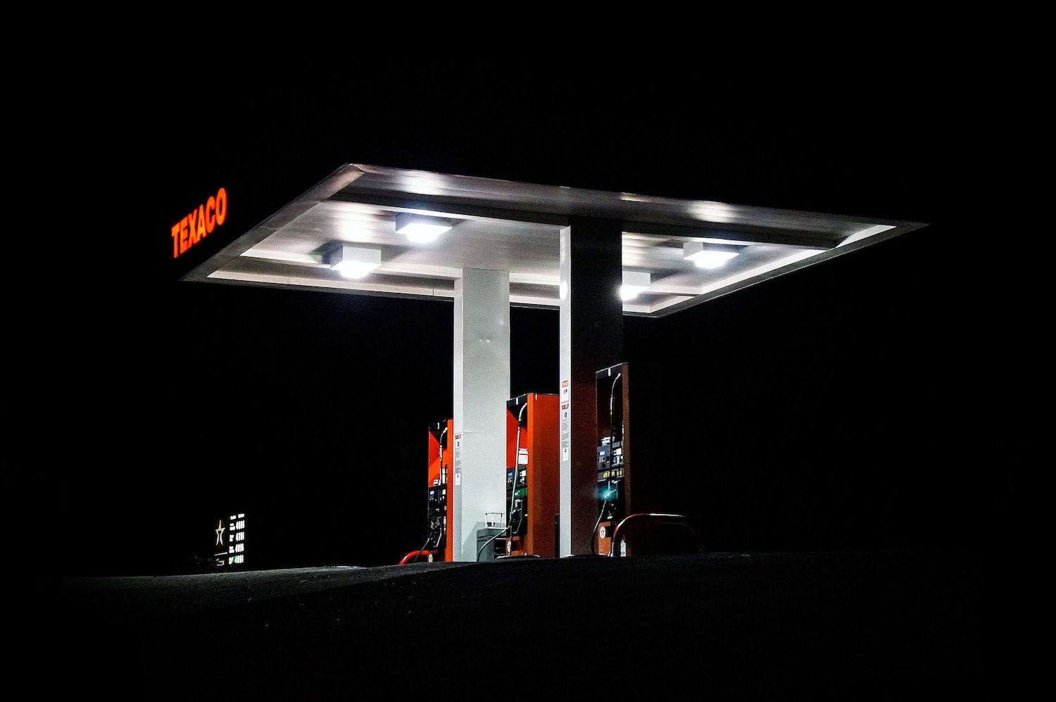 The silhouette of an illuminated gas station canopy at night with off road diesel for sale.