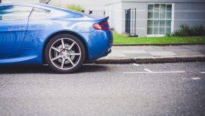 a blue car sits in front of the empty parking spot