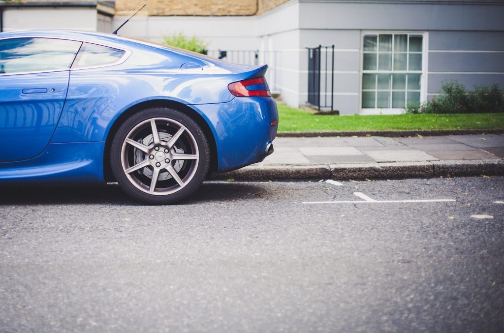 An Aston Martin sits in front of a prime parallel parking spot. | Clem Onojeghuo on Unsplash