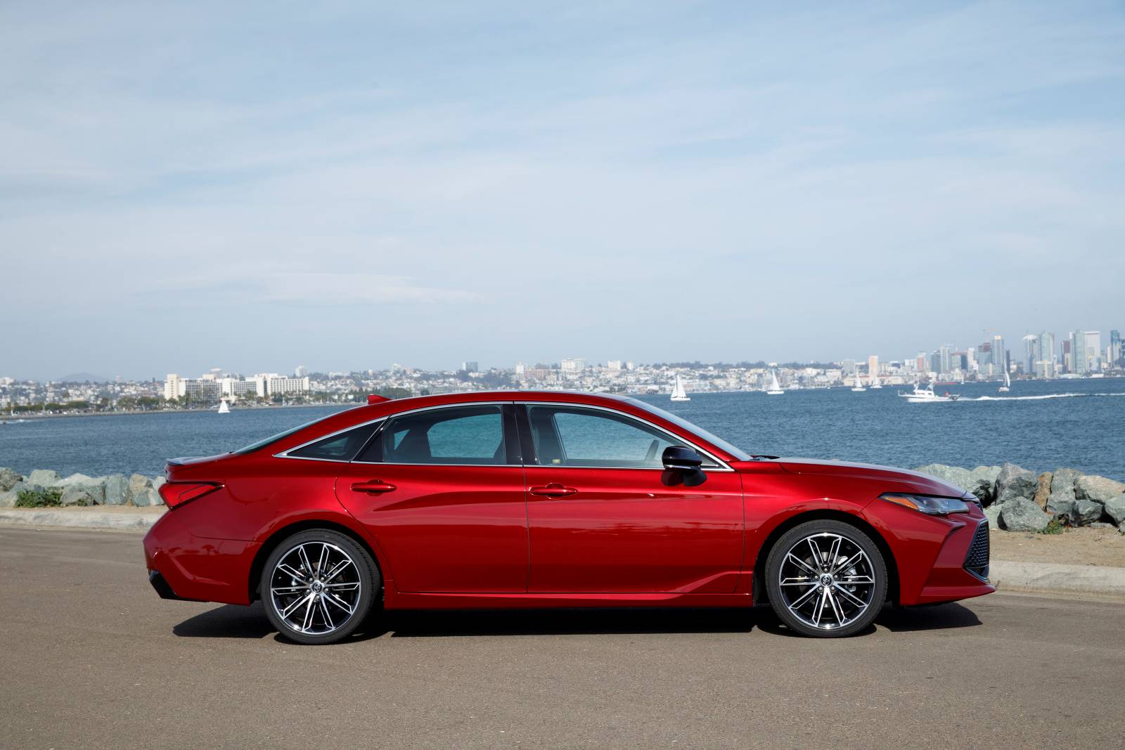 Side profile of a red 2022 Toyota Avalon, a very reliable car for Uber or Lyft driving