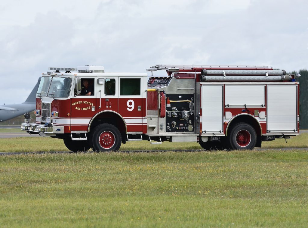 A fire engine truck parked in a field.
