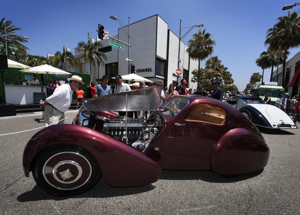 The burgundy 1931 Bugatti Type 51 Dubos Coupe with its hood open on the streets of Beverly Hills, California