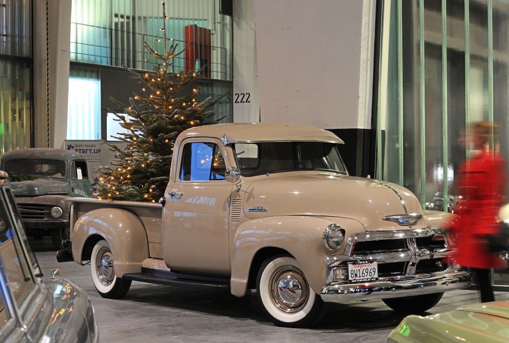 Vintage Chevrolet 3100 pickup truck parked in a hotel lobby, a christmas tree in its bed.