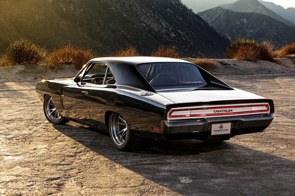 Black 1970 Dodge Charger parked in front of a mountain range.