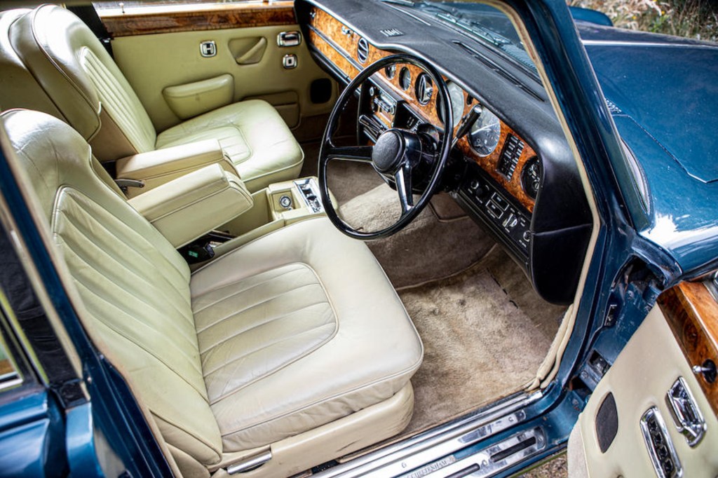 The beige-leather front seats and walnut-lined dashboard of a blue 1979 Bentley T2