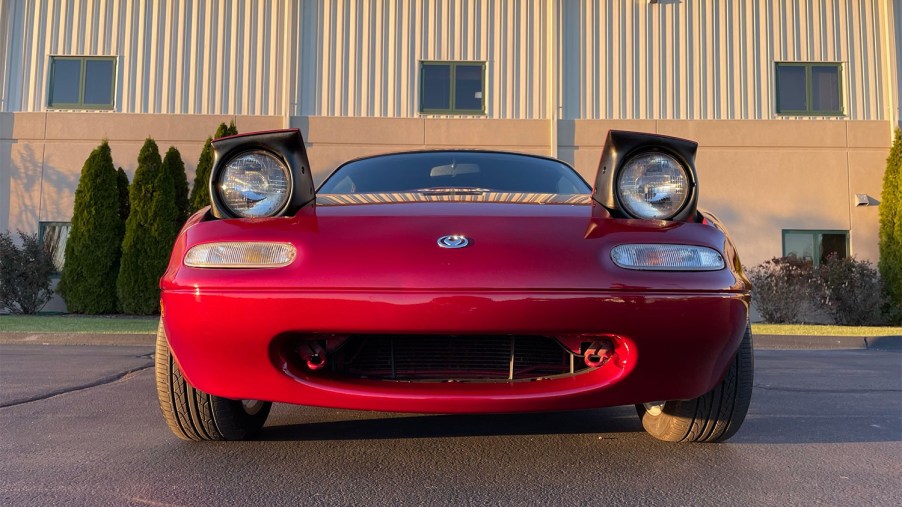 Front of red 1994 Mazda Miata with headlights up