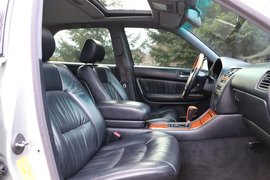 The black-leather front seats and black dashboard of a silver 2000 Lexus LS 400 Platinum Series seen from the passenger's side