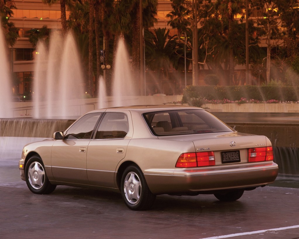 The rear 3/4 view of a beige 2000 Lexus LS 400 by a fountain
