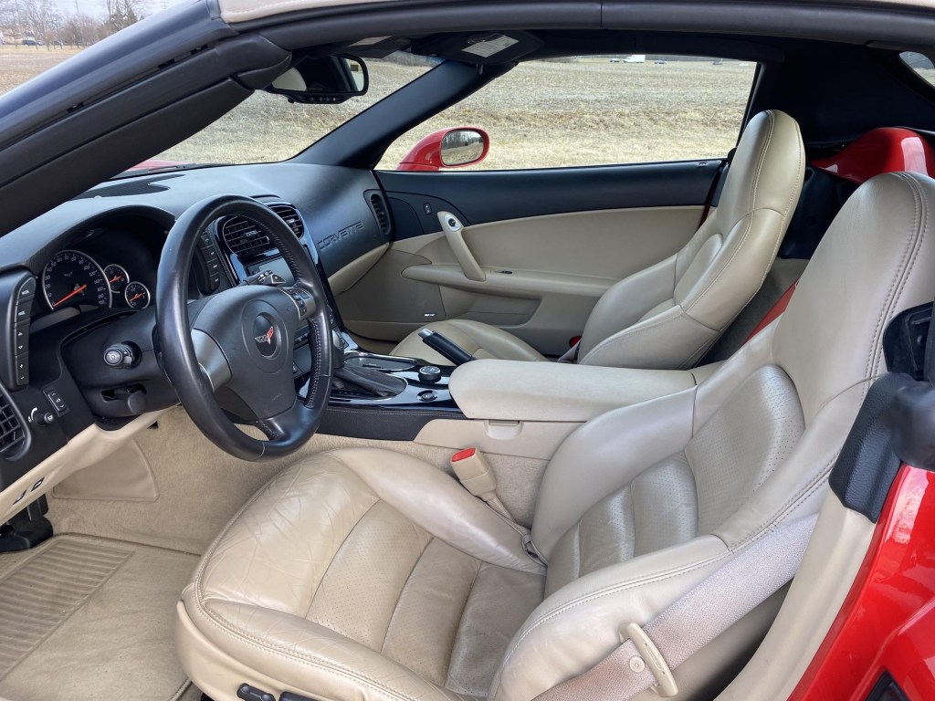 The side view of a red 2008 Chevrolet Corvette 3LT Convertible's tan-leather seats and black dashboard
