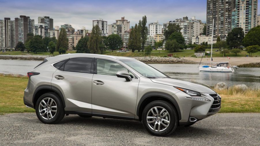 A gold 2022 Lexus NX parked in front of a city.