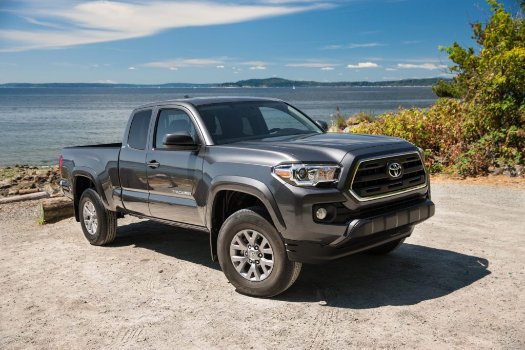 A Toyota Tacoma mid-size truck shows off its attractive styling in front of the water.
