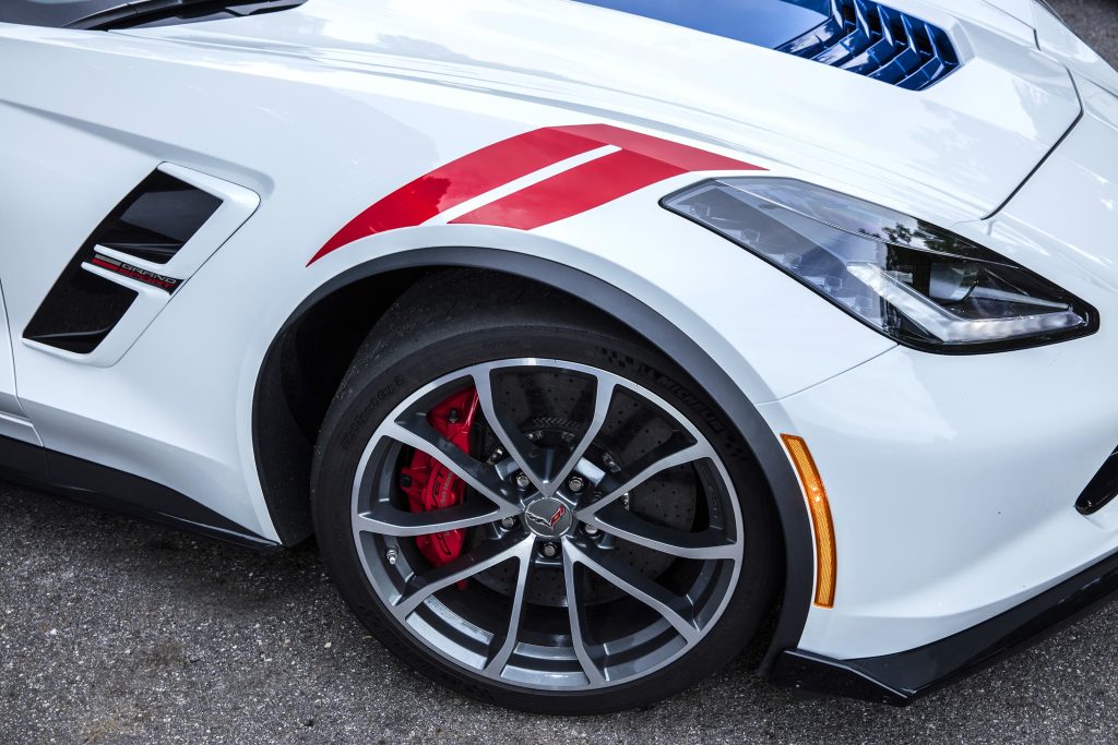 Close-up view of the front passenger front wheel of a 2017 Chevrolet C7 Corvette Grand Sport with white-red-and-blue stripes