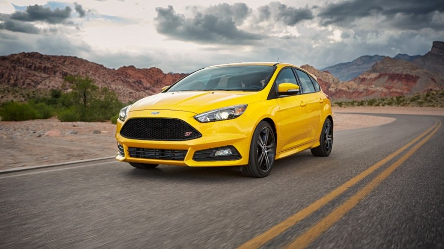 A yellow 2017 Ford Focus ST drives through the desert