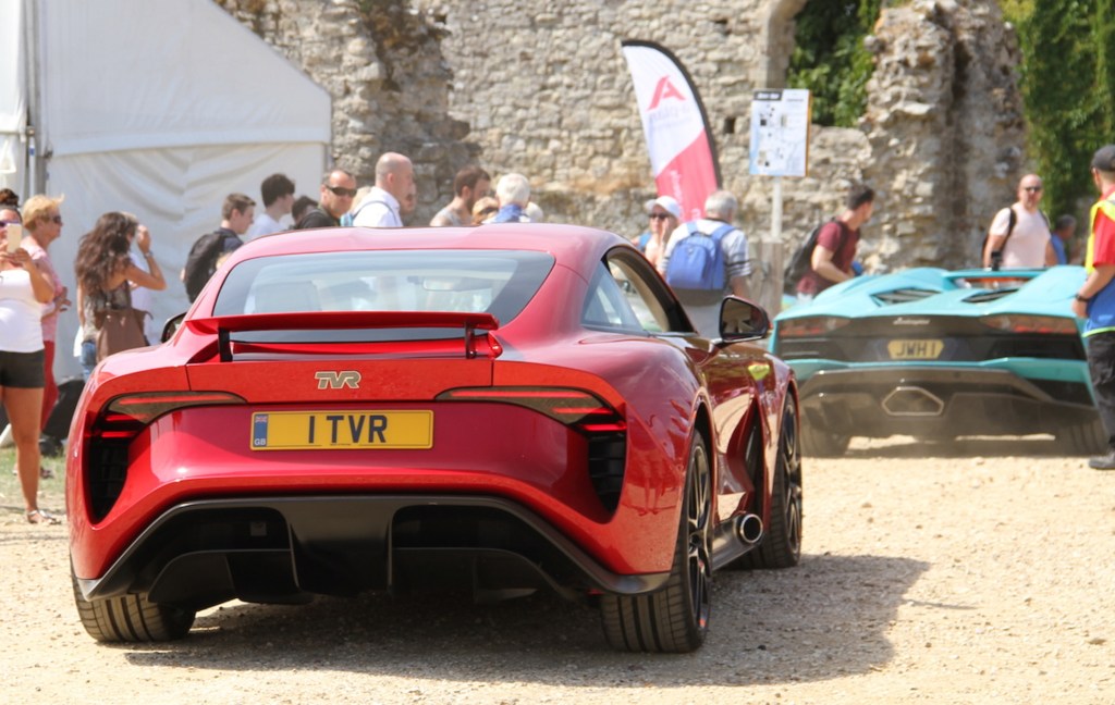 The rear 3/4 view of the red 2017 TVR Griffith V8 Prototype behind a blue Lamborghini at the 2017 Beaulieu Supercar Weekend