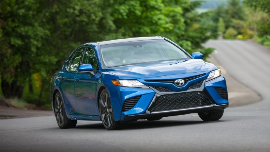 A blue 2019 Toyota Camry XSE taking a corner sharply on a winding country road