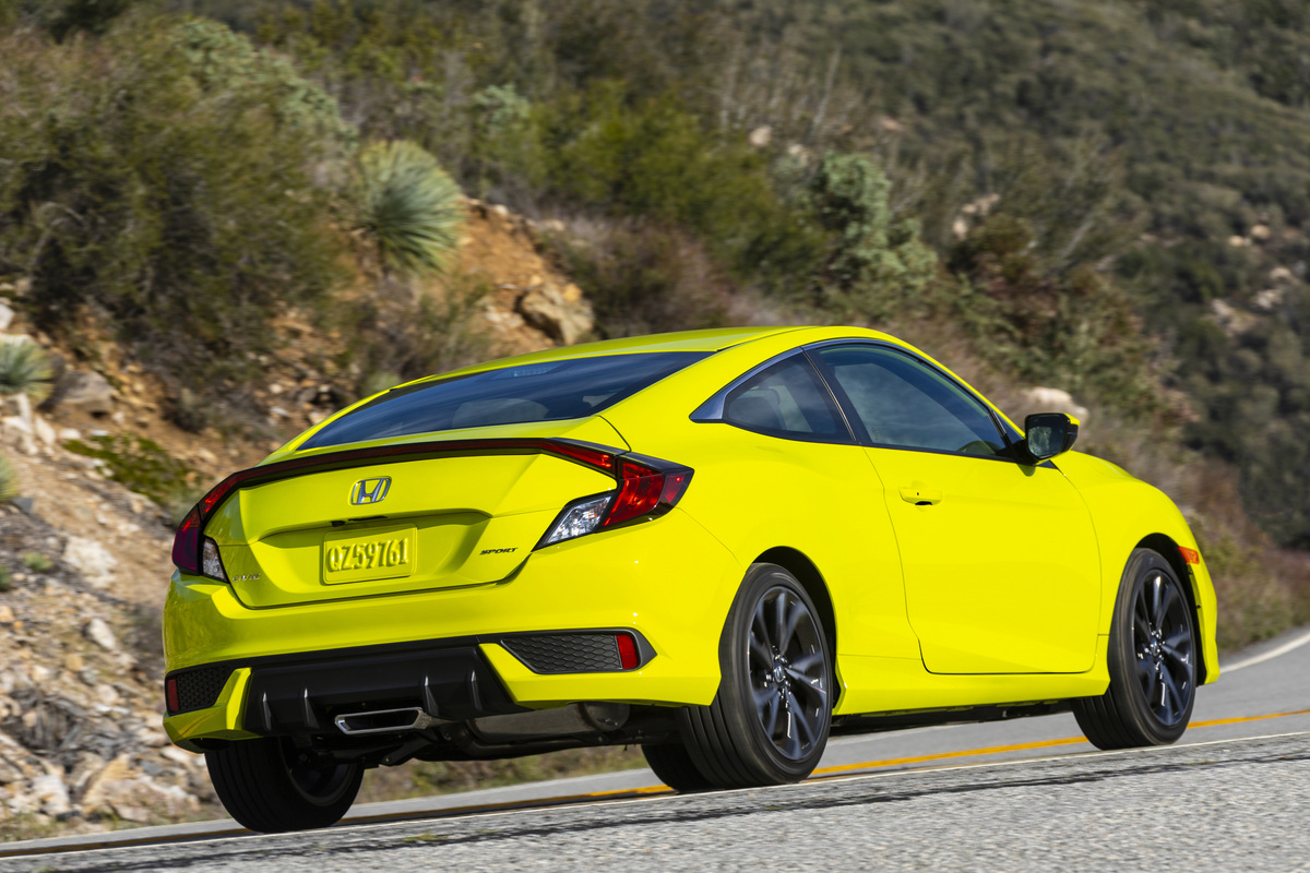 Rear angle view of a 2020 Honda Civic Sport coupe on a mountain road