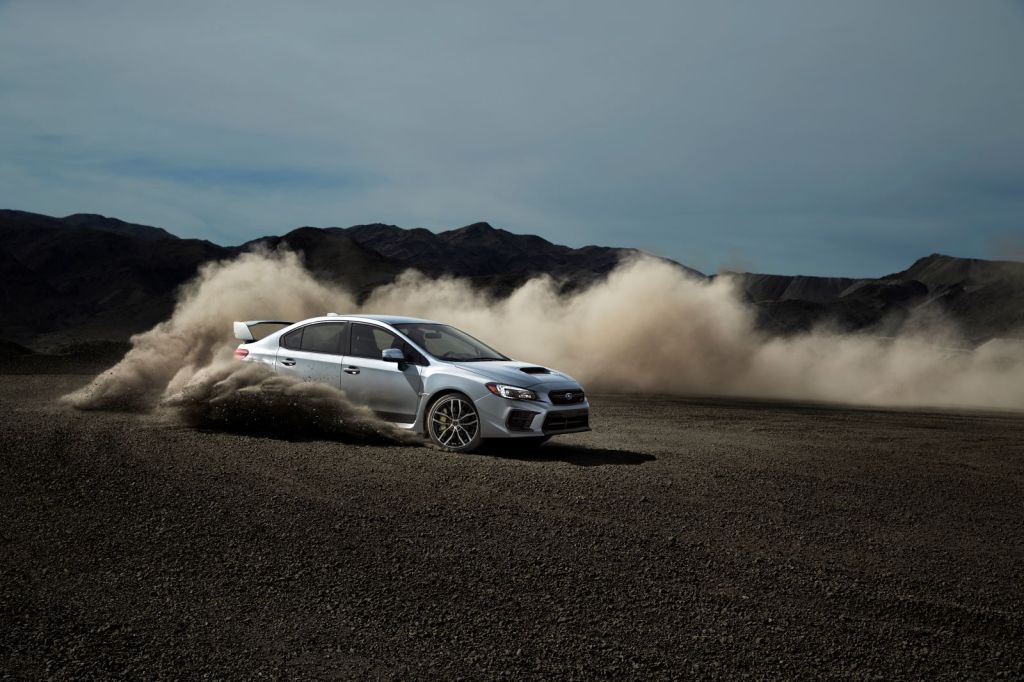 Silver 2021 Subaru WRX STI drifting in dirt, kicking up dust behind its rear wheels